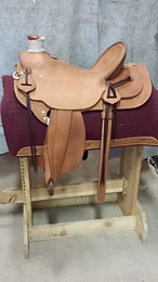 BS100 — Rough-out Wade semi-square skirt w/ inskirt rigging, exposed stirrup leathers, and horn flower.